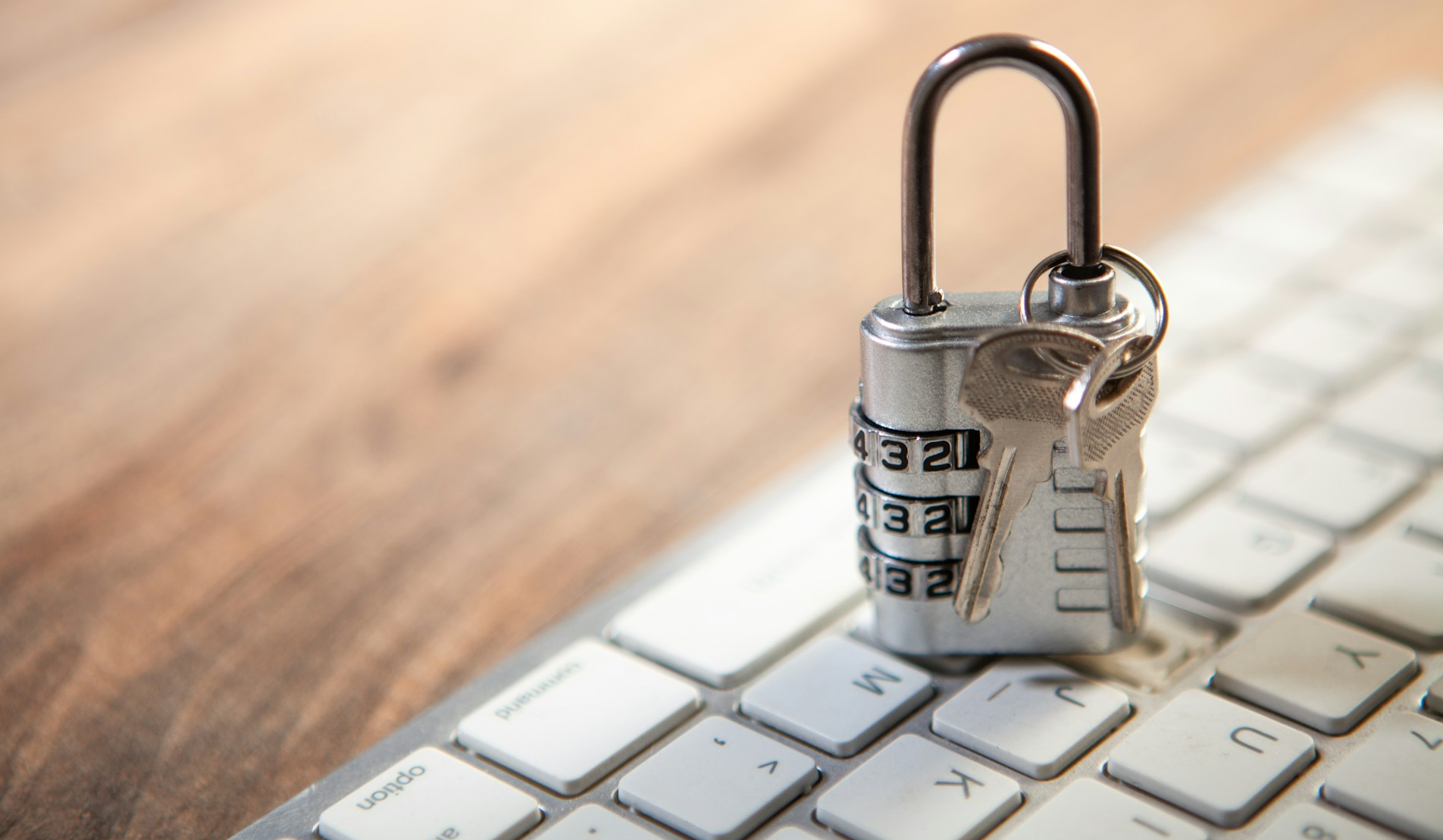 Padlock resting on top of a laptop's keyboard.