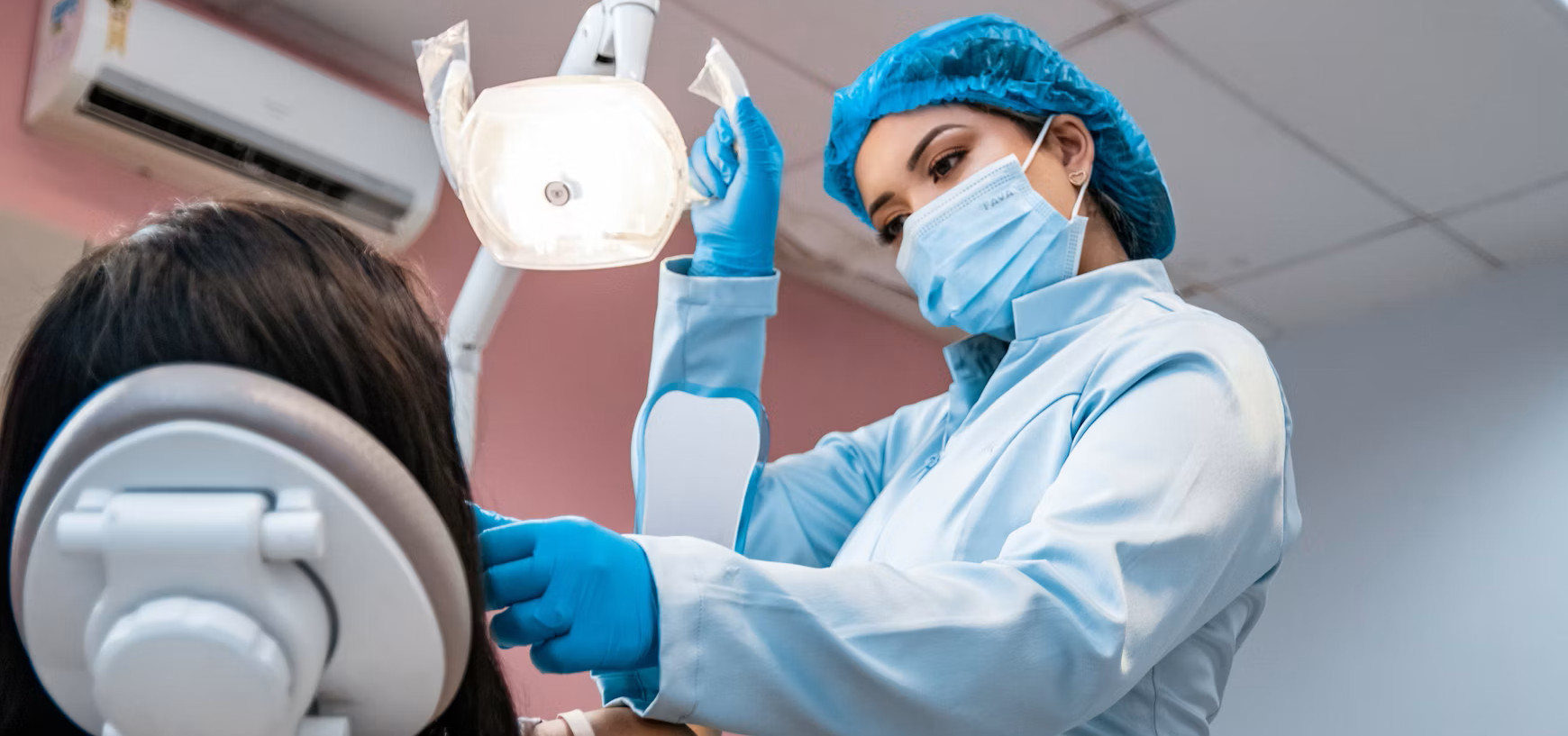 A dental hygienist examines a patient's teeth.