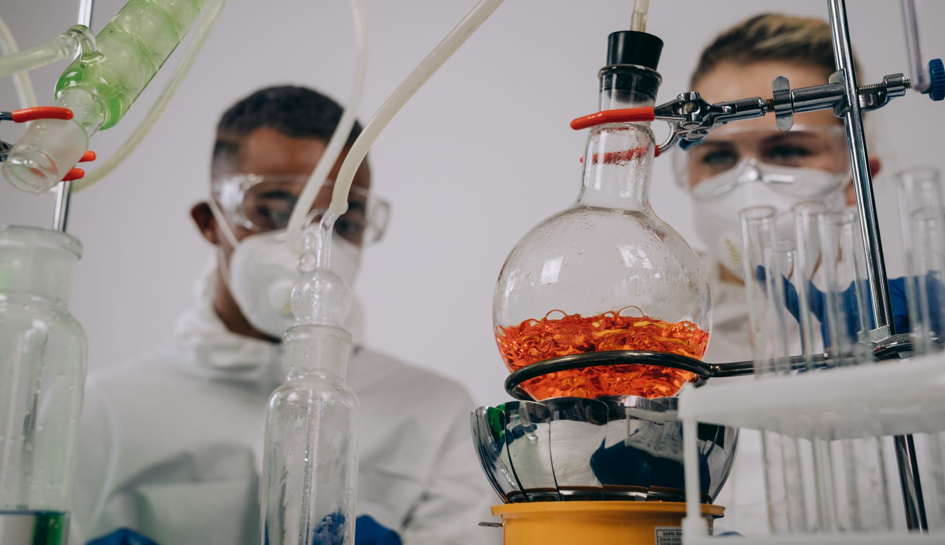 Two scientists in protective gear conducting experiments in a laboratory setting.