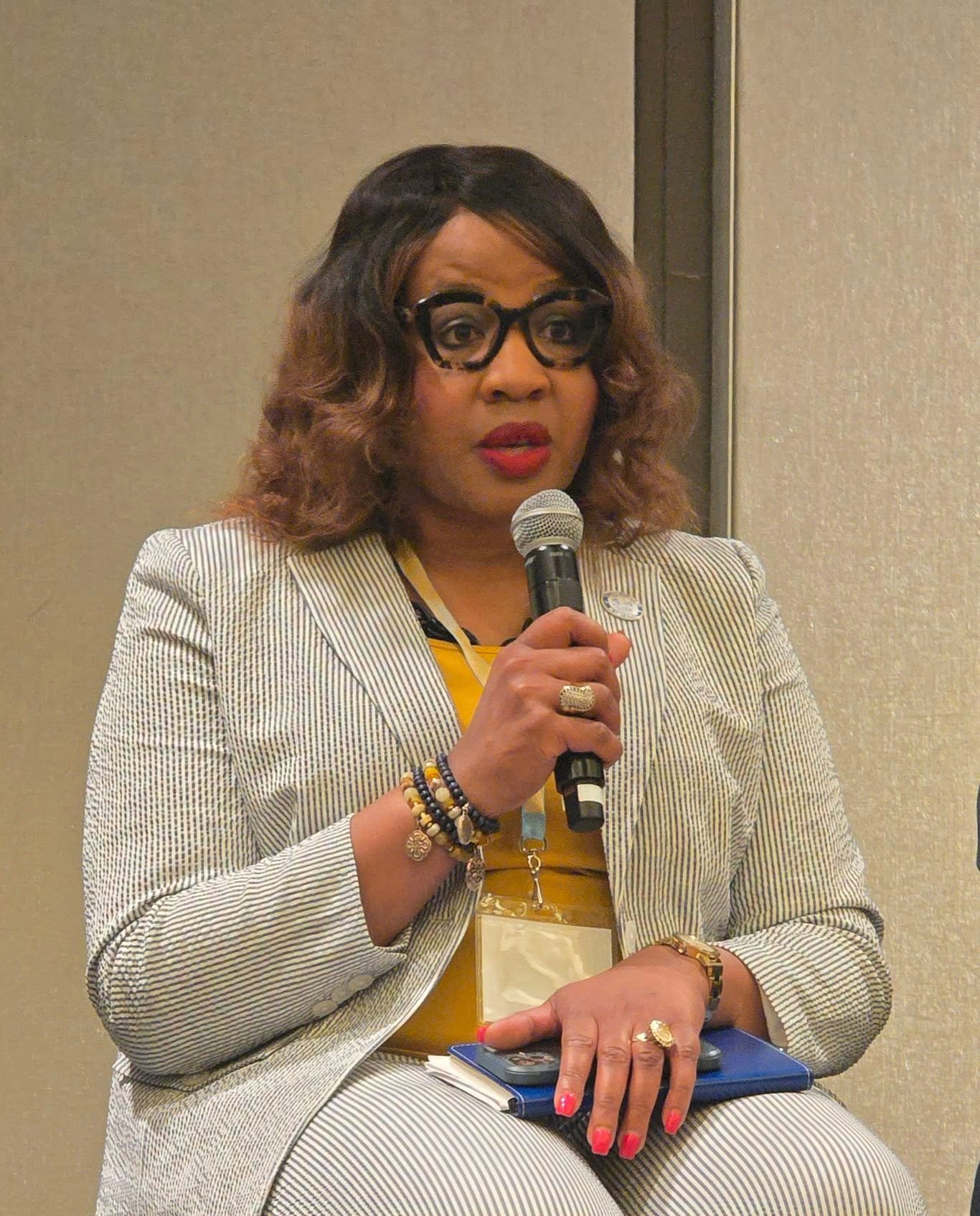 Dr. Aubra J. Gantt holding mic, speaking at conference.