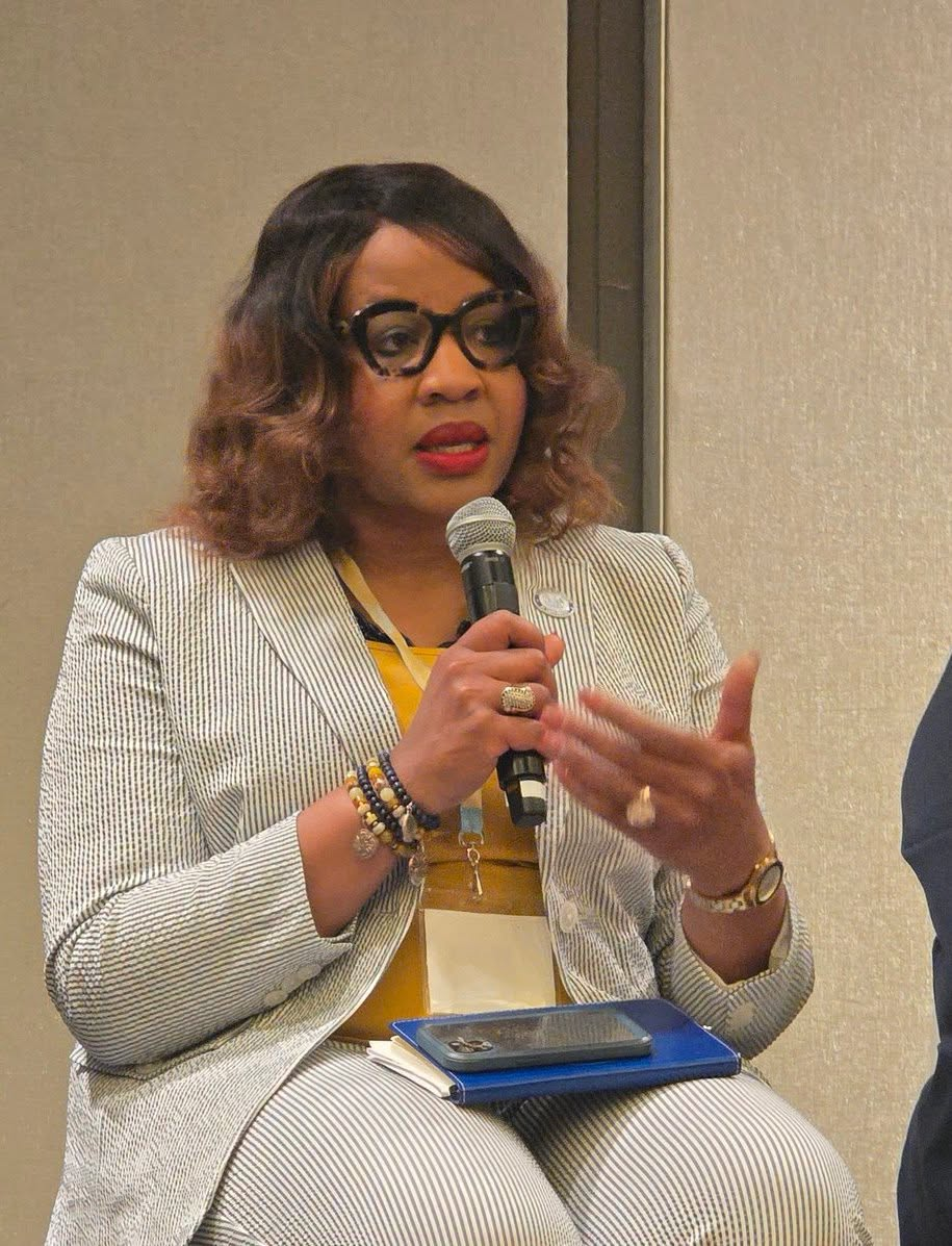 Dr. Aubra J. Gantt holding mic, speaking at conference.
