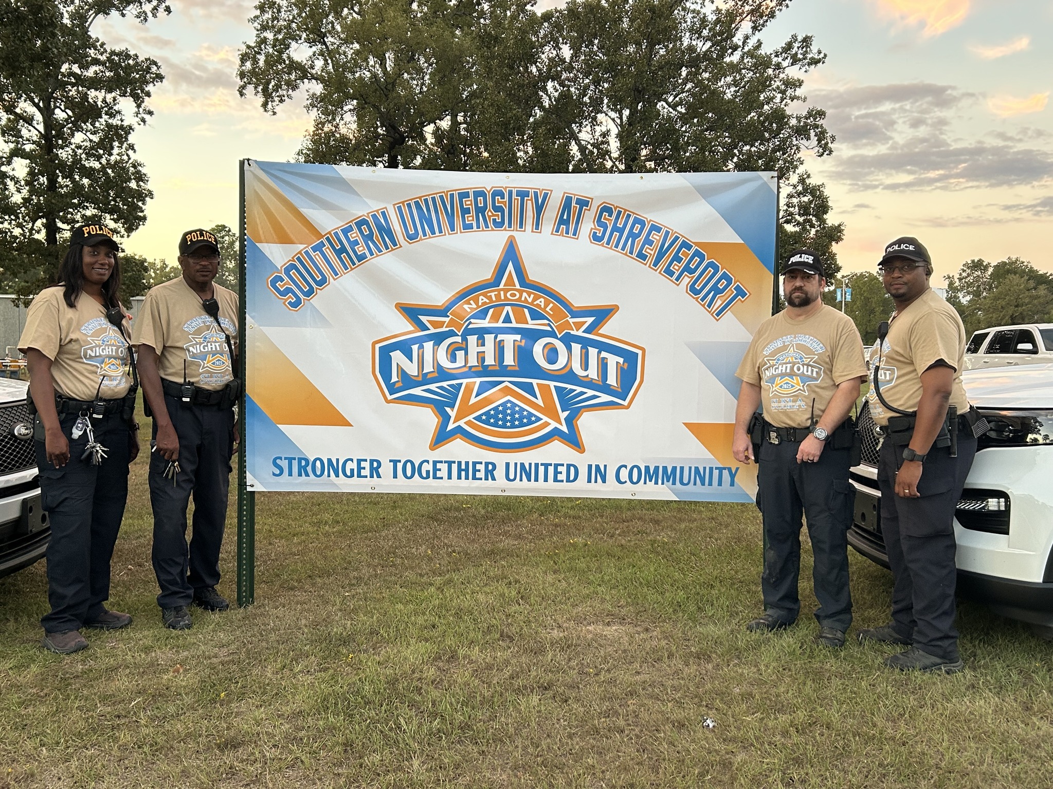 Dr. Gantt with SUSLA police force in front of a sign that says "National Night Out: Stronger Together, United in Community"